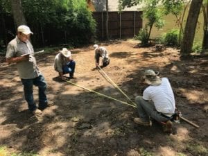 Four men measure for a pool build