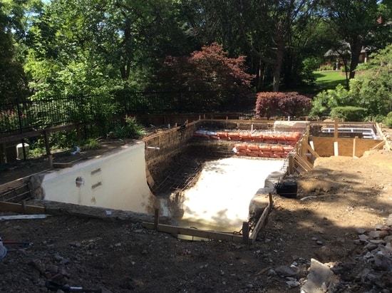A pool under construction to increase in the size and depth.