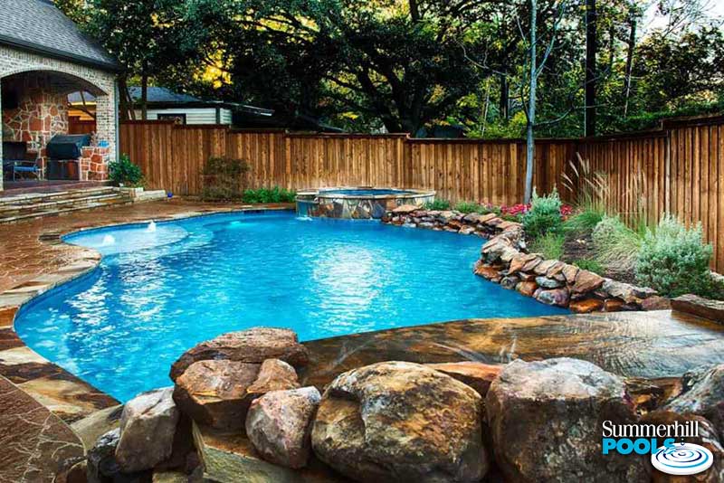 A free form pool with rock ledges and spa.
