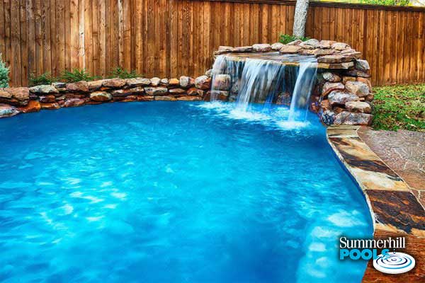 rock waterfall into a residential pool
